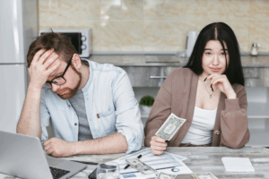 Worried couple reviewing budget